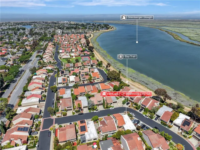 Sweeping aerial view showcasing the home's proximity to the shoreline and surrounding coastal area.