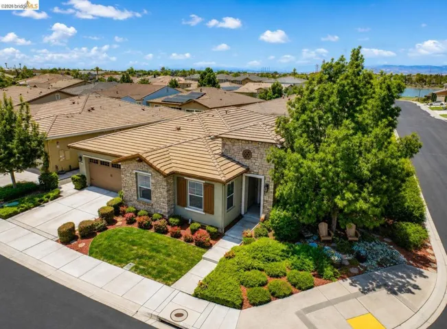 Single-story residence featuring a tile roof, stone facade accents, and a two-car garage
