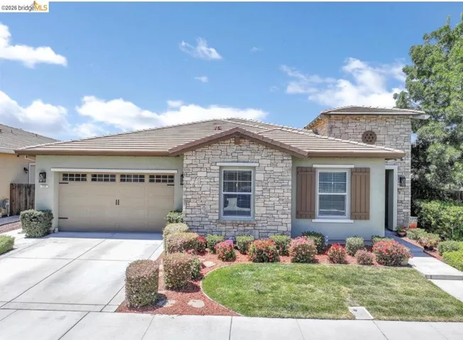 Stone veneer and stucco exterior with a tiled roof