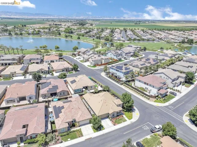 Aerial perspective showcasing a residential community with a large central lake featuring a fountain