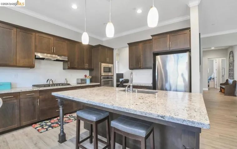 Spacious kitchen featuring dark wood cabinetry, light-toned countertops, and a white subway tile backsplash