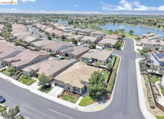 Residential neighborhood featuring a mix of single-story and two-story homes with tile roofs, manicured lawns, and mature landscaping