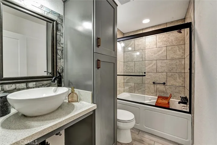 Hall bathroom with oversized jetted tub designer vessel sink, and plenty of storage space.