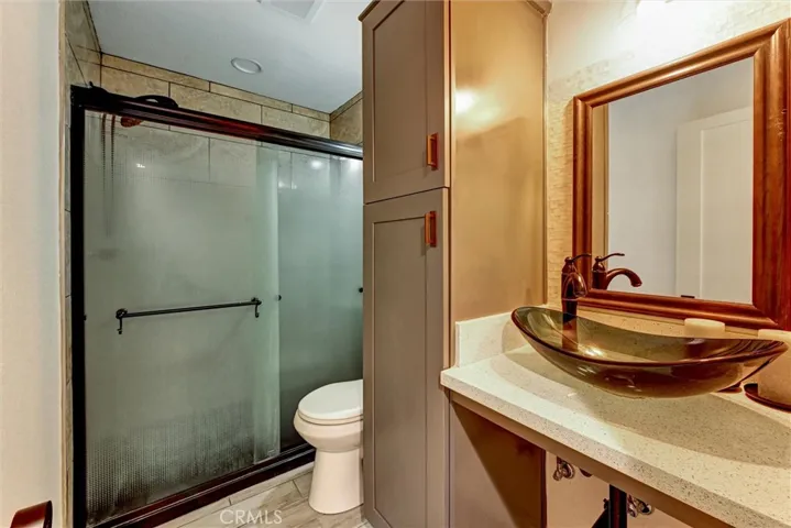 Primary bathroom with designer vessel sink and oversized walk-in shower.