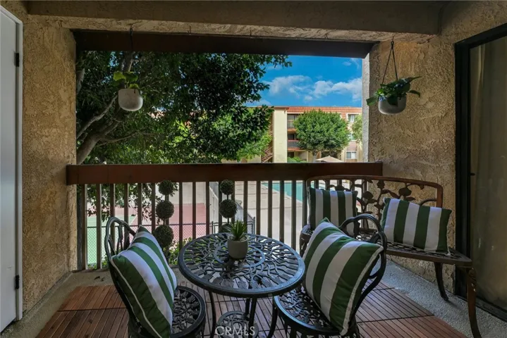 Balcony overlooks the tennis courts and pool area.
