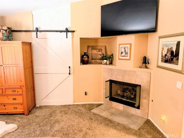 Primary bedroom fireplace and barndoor entry to bathroom