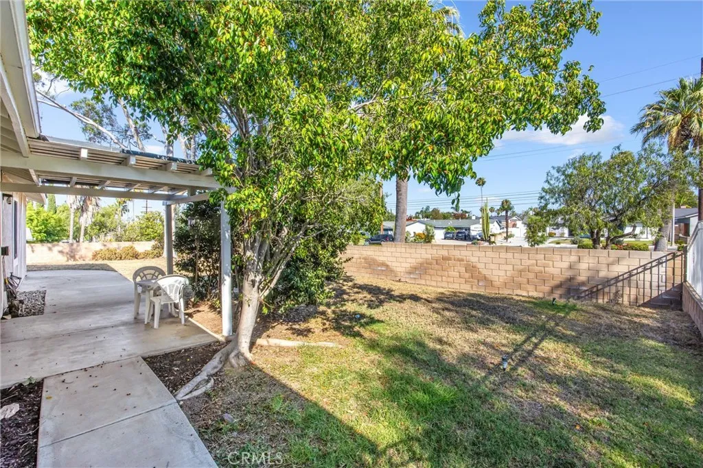 Spacious backyard with covered patio and mature landscaping