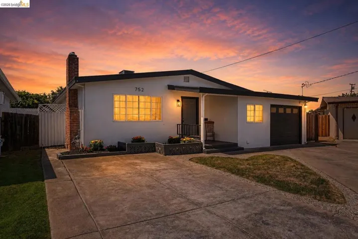 Contemporary single-story residence featuring a smooth stucco exterior and a dark trim roofline