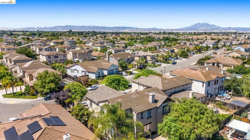 Aerial perspective of a residential neighborhood featuring single-family homes with tile roofs and mature landscaping