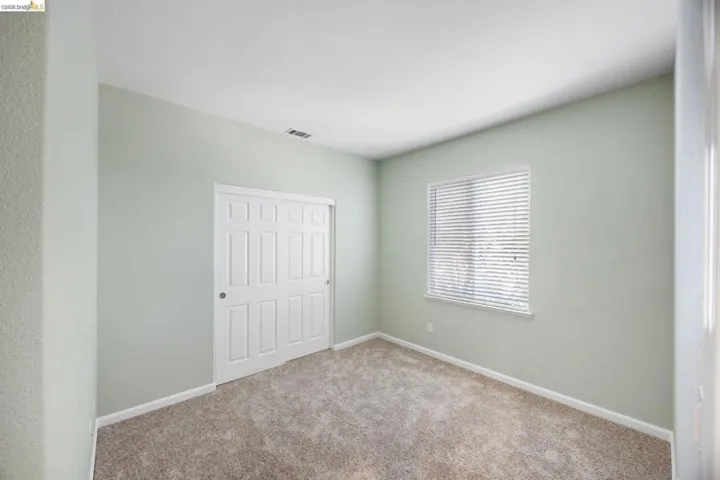 Neutral-toned carpet flooring complements light green walls and white trim
