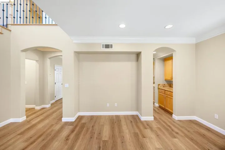 Spacious interior featuring wood-finish flooring, recessed lighting, and crown molding