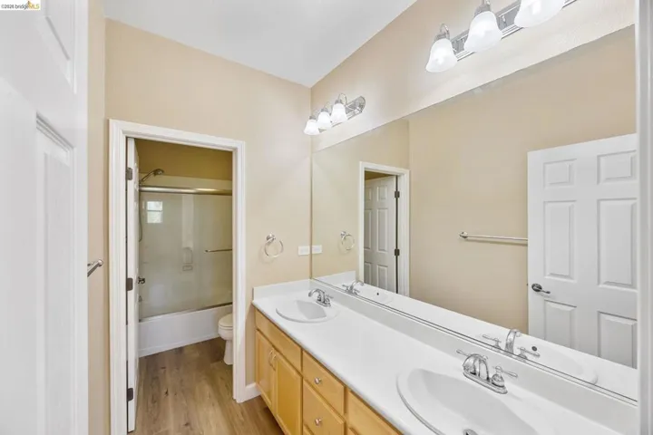 Dual vanity with white undermount sinks, chrome faucets, and a full-width mirror