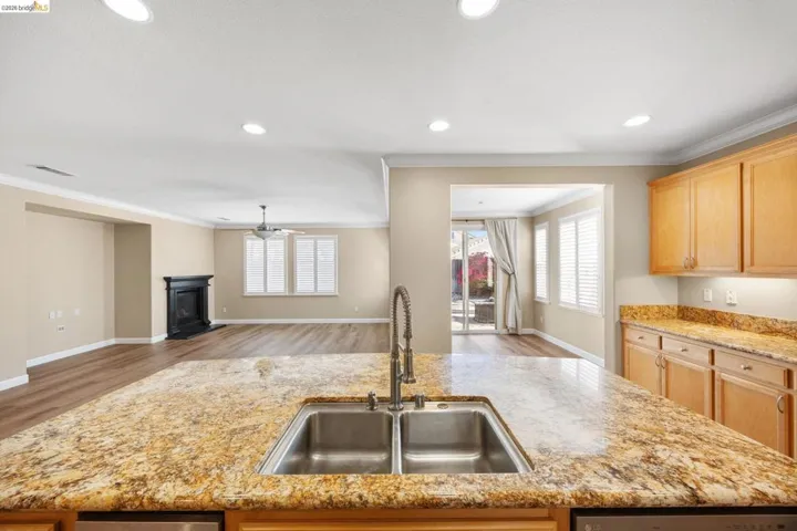 Kitchen island featuring a double basin stainless steel sink with a gooseneck faucet