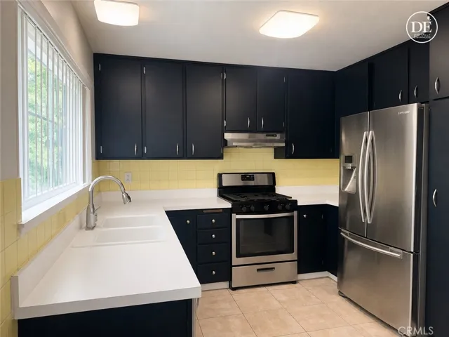 Functional kitchen with a large window that looks out to porch balcony