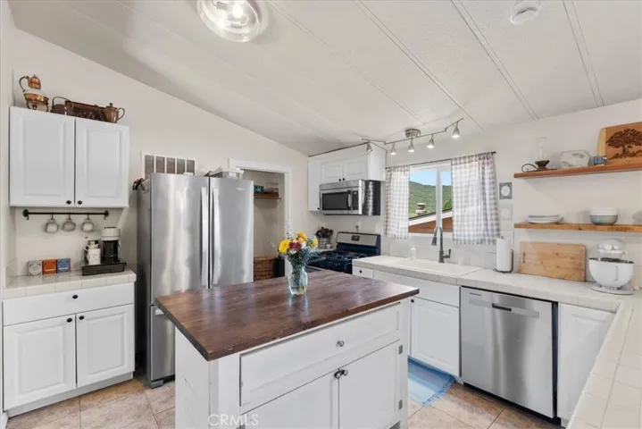 Open kitchen with island and newer dishwasher.