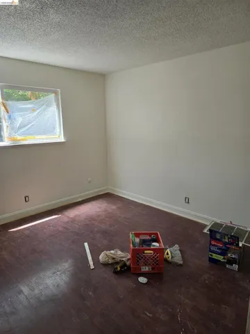 Room featuring wood-finish flooring, white baseboards, and neutral wall tones