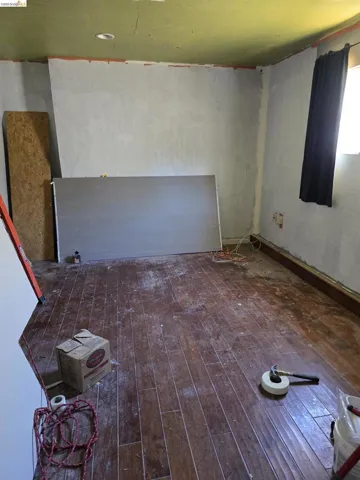 Room featuring wood-finish flooring, recessed ceiling lighting, and a single window