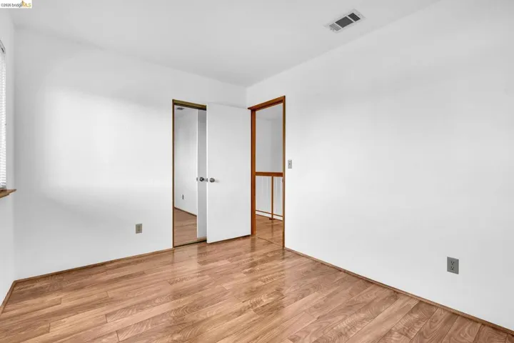 Room featuring wood-finish flooring and white painted walls