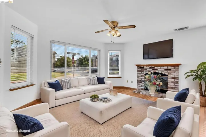 Living area featuring wood-finish flooring and a brick-surround fireplace with a wood mantle