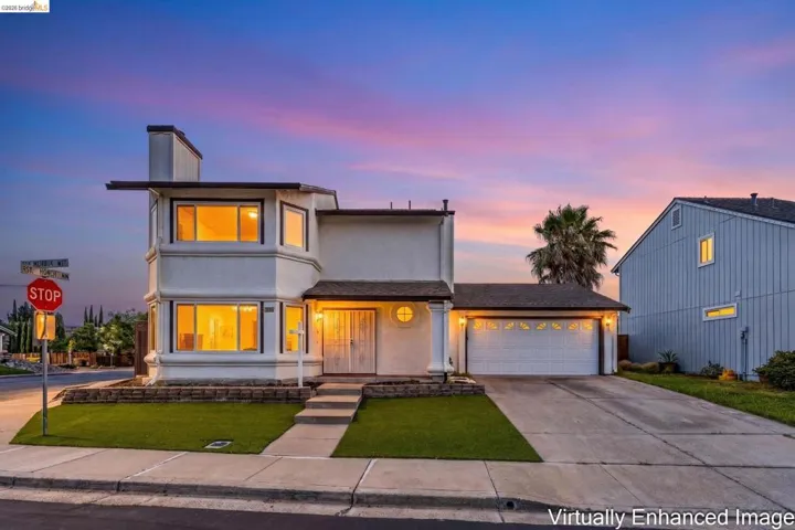 Two-story residence featuring a two-car garage, bay windows on both levels, and a covered entry