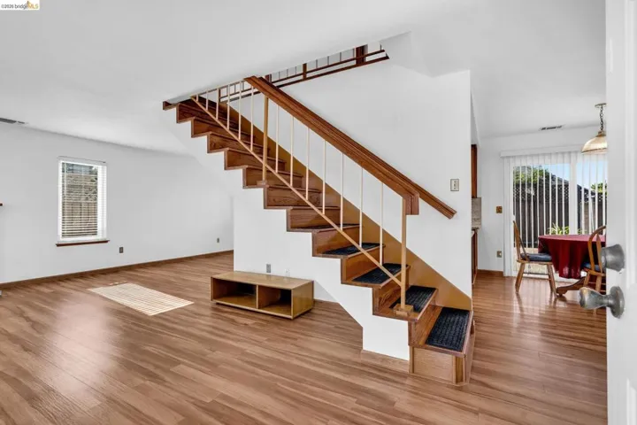 Two-story staircase with wood-finish treads and railings