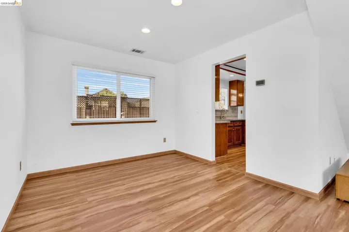 Bright room featuring wood-finish flooring and recessed lighting