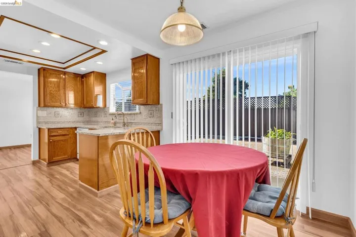 Kitchen with wood-finish flooring, custom wood cabinetry, and a light-toned countertop