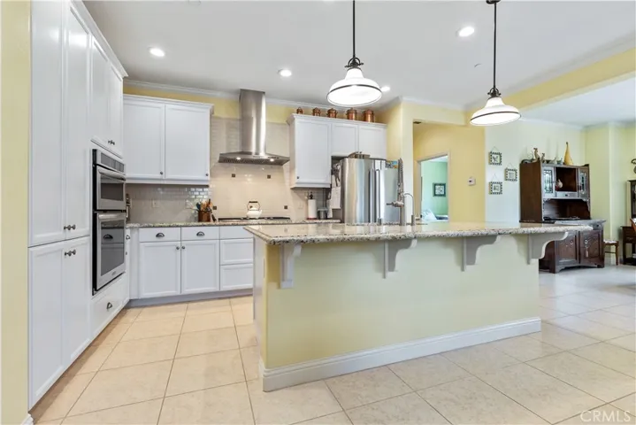 Kitchen with island. Stainless steel applieances, pull out drawers in cabinets.