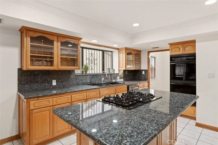 Gas cooktop island & granite backsplash.