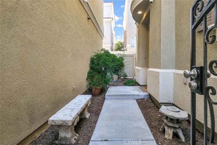 View of walk way from street behind gate toward front door and rear yard