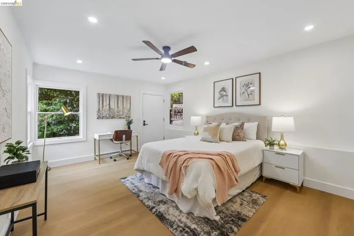 Light-filled bedroom featuring vinyl plank flooring, recessed lighting, a ceiling fan, and multiple windows