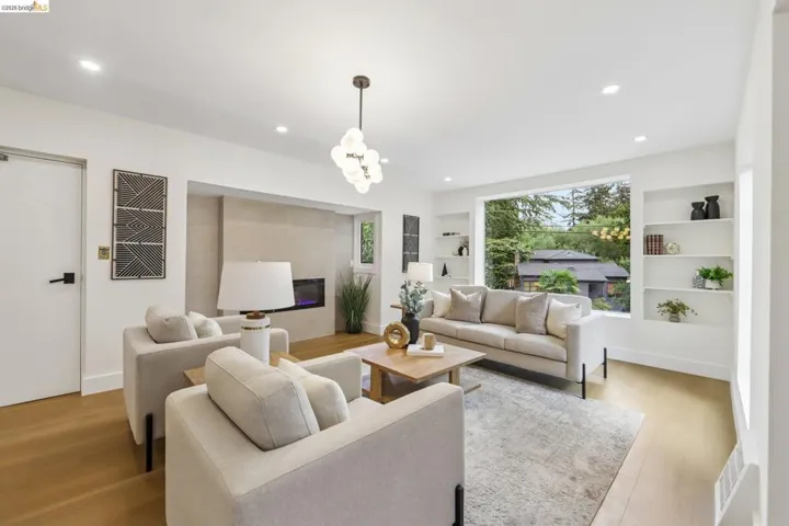 Open-concept living area featuring new vinyl plank flooring, recessed lighting, new entry door with frosted glass panels, new electric fireplace and a brand new front picture window. Elevator.