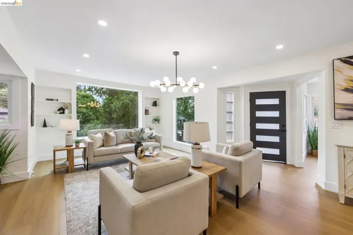 Open-concept living area featuring new vinyl plank flooring, recessed lighting, new entry door with frosted glass panels, and a brand new front picture window.