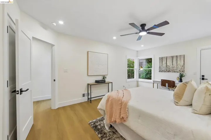 Bright interior featuring vinyl plank flooring, recessed lighting, white walls, a ceiling fan, and a window overlooking exterior greenery