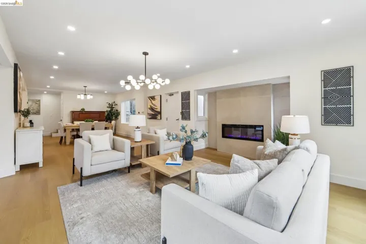 Open-concept living area featuring new vinyl plank flooring, recessed lighting, new entry door with frosted glass panels, new electric fireplace and a brand new front picture window. Elevator.