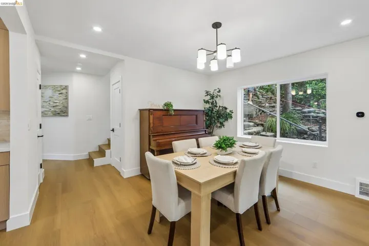 Dining area with vinyl plank flooring and a contemporary chandelier