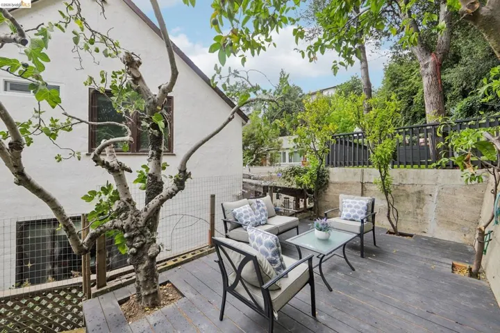 Expansive outdoor deck with dark-finish wood flooring and mature surrounding foliage
