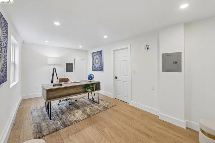 Bright room featuring vinyl plank flooring, recessed ceiling lighting, a panel door