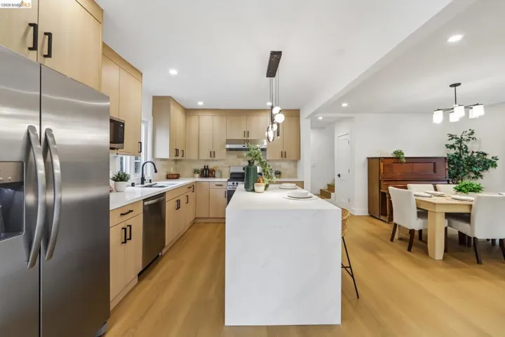 Modern kitchen featuring light wood-finish cabinetry and stainless steel appliances
