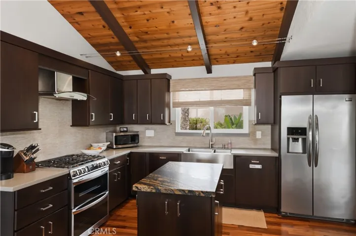 The stainless steel appliances and farmhouse sink embrace the sleek lines of the modern kitchen.