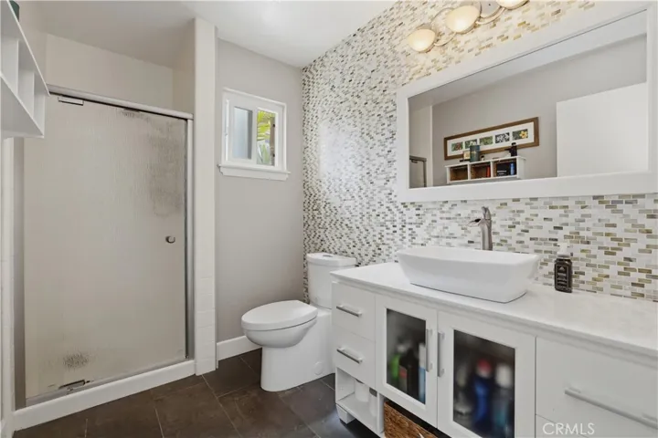 This is the bathroom on the lower level with beautiful tile, lovely lighting and designed for easy cleaning.