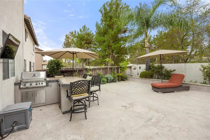 Designed for outdoor entertaining, the backyard features a built-in BBQ with counter seating, mature landscaping, and plenty of space to relax or host family and friends.