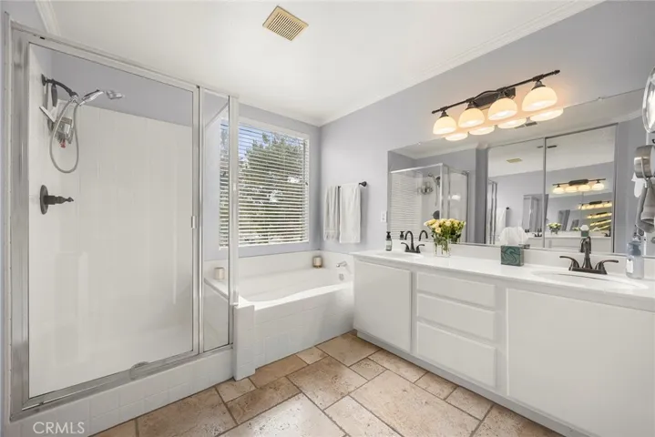 Bring your Pinterest inspiration to life and transform this spacious primary bath into the spa-like retreat you've always envisioned. Features include dual vanities, a separate soaking tub, and a walk-in shower.