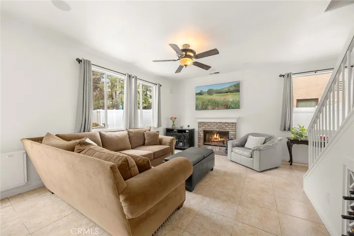 The "hub" of the home.  A bright and welcoming open concept room featuring a cozy fireplace, oversized windows, and an open layout that creates the perfect space for relaxing or entertaining.