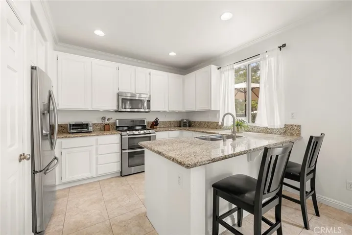 The kitchen is ready for your personal touch.  It features granite countertops, stainless steel appliances, ample storage, and convenient bar seating. Also a large window overlooking the backyard.
