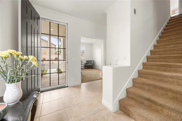 The spacious entry welcomes you with abundant natural light, easy-care tile flooring, and access to the downstairs bedroom, with three additional bedrooms located upstairs.