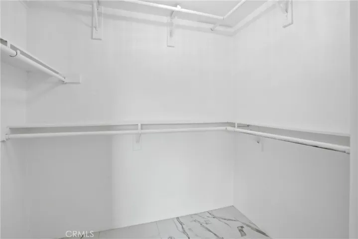 This full sized primary bedroom walk-in closet