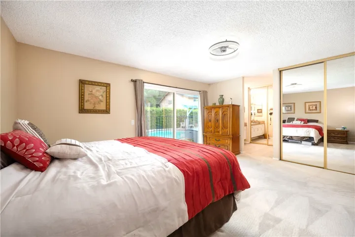 The Primary Bedroom offers triple mirrored closet, sliders to the serene rear yard.