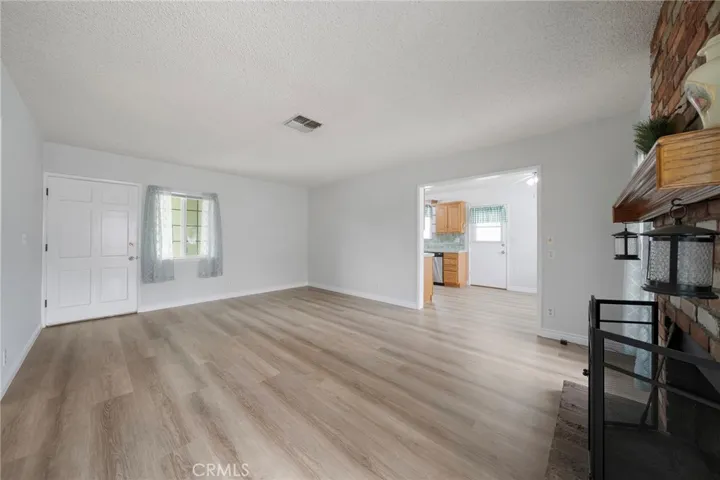 New paint and brand new flooring throughout. Front door to kitchen view.