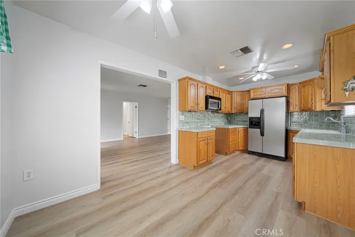 Large bright kitchen with lots of windows and ceiling fans.